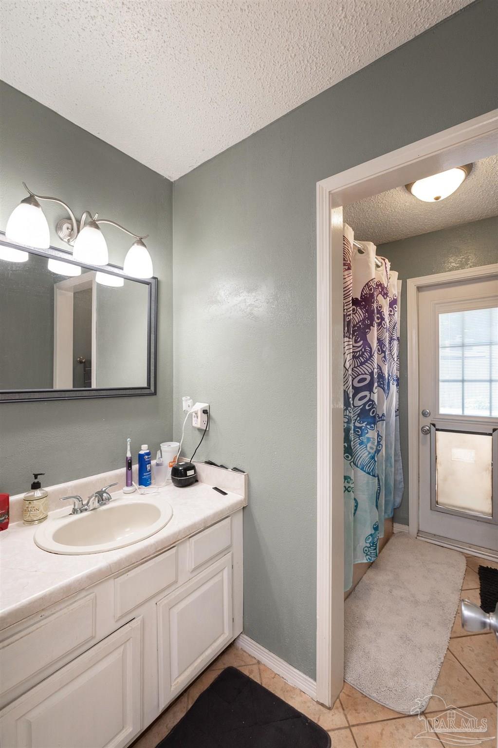 2322 Silversides Loop Pensacola, FL 32526 - Photo 17 of 29 a bathroom with a sink a mirror and a shower