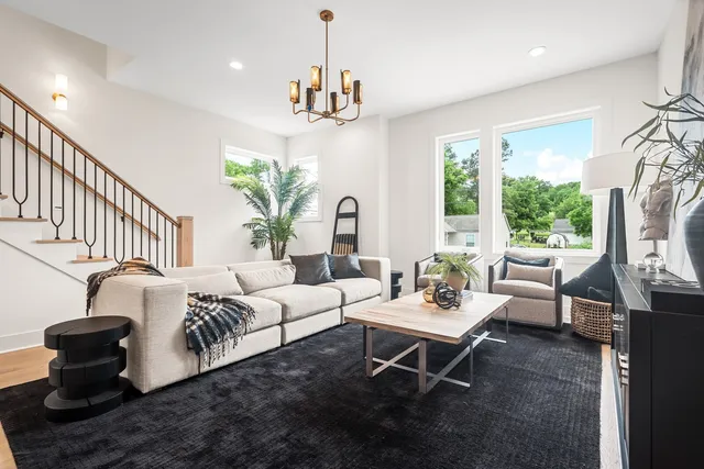 a living room with furniture chandelier and a fireplace