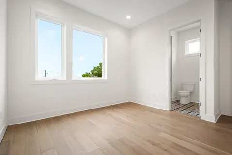 an empty room with wooden floor and a window