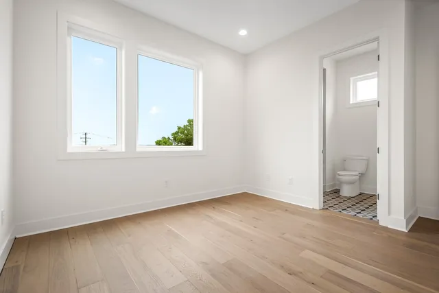 an empty room with wooden floor and a window