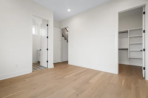 a view of empty room with wooden floor and closet