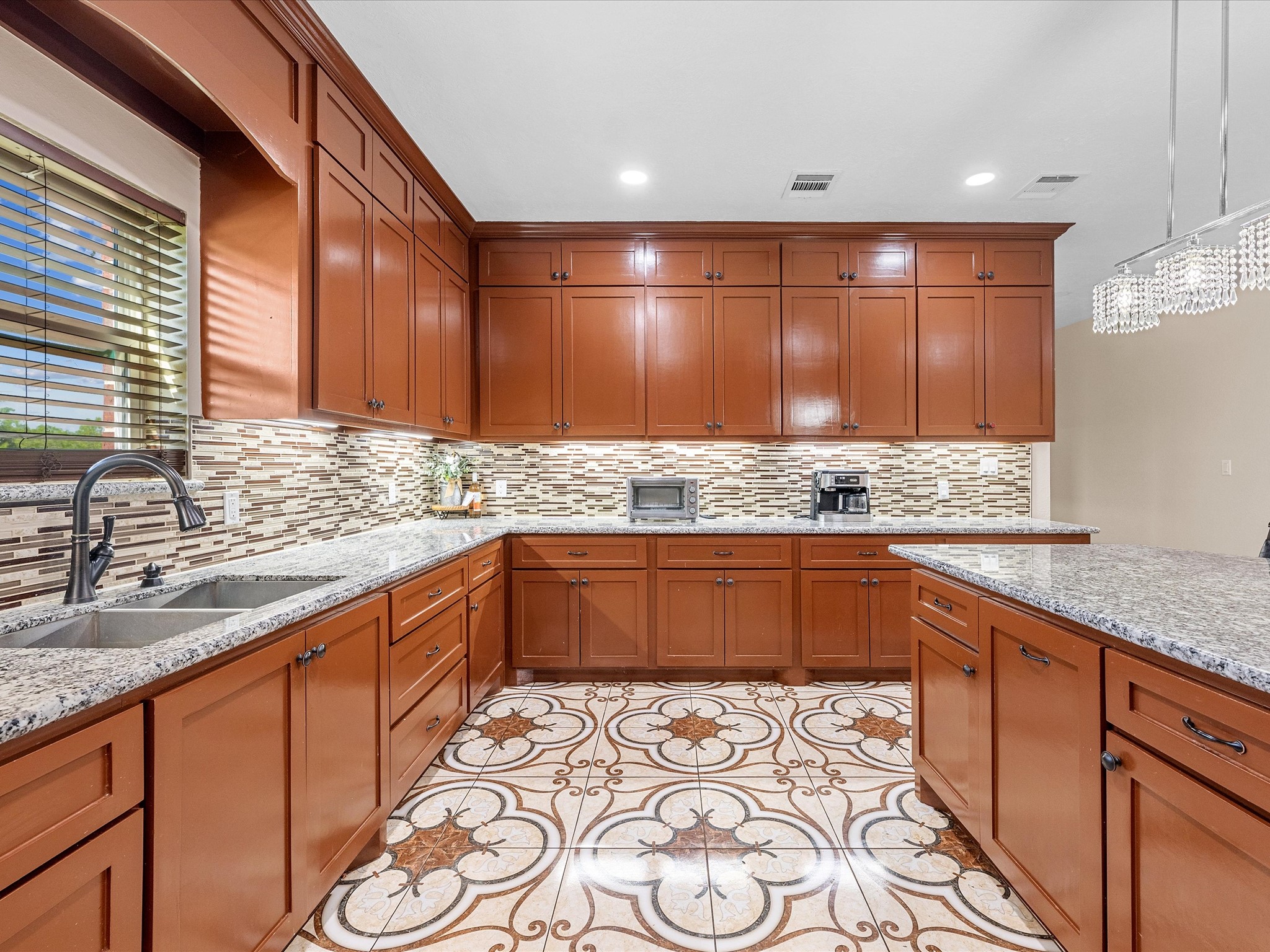 886 Zilss Road La Grange, TX 78945 - Photo 13 of 50 a kitchen with stainless steel appliances wooden cabinets a stove a sink and a window