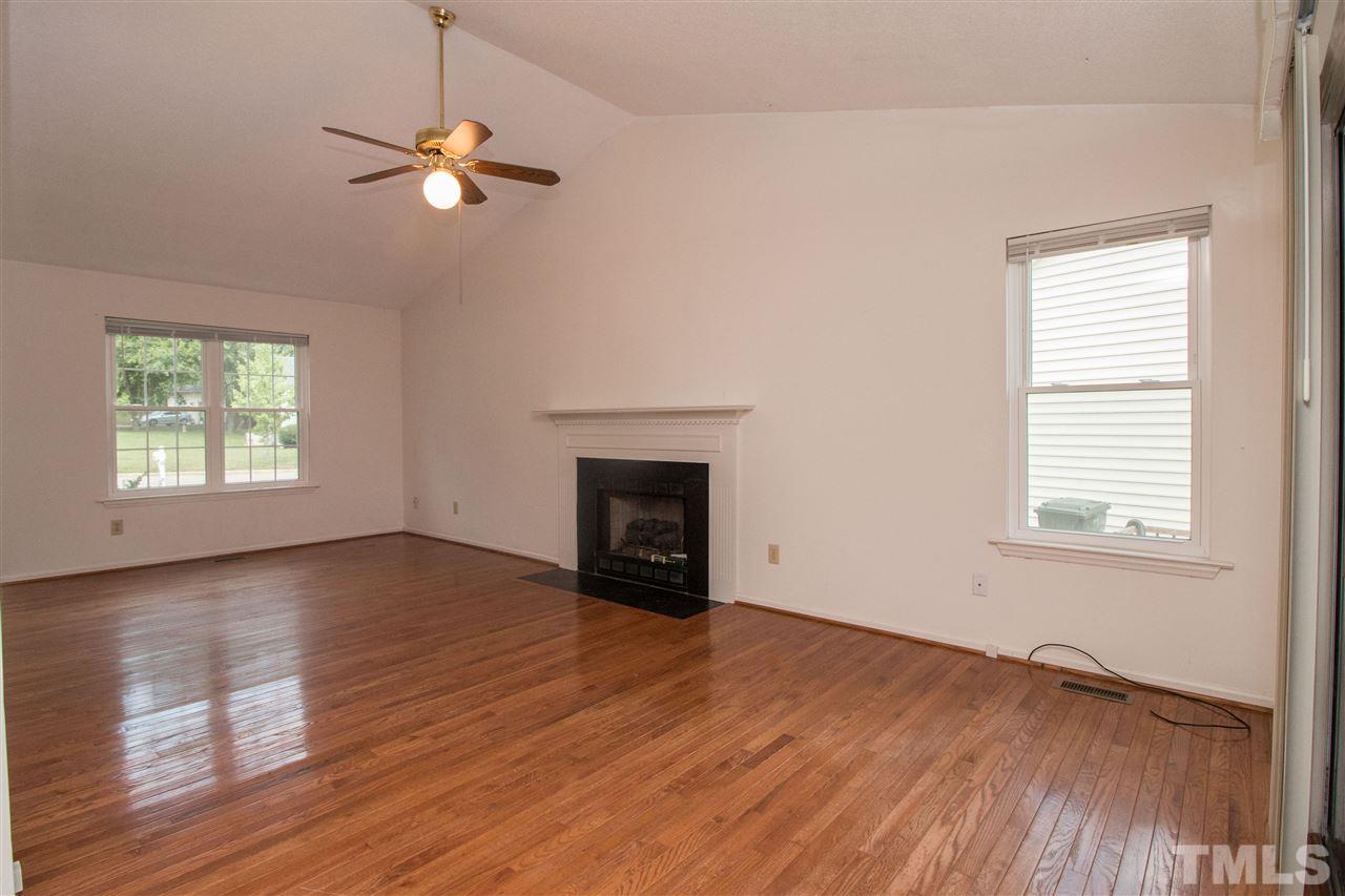 2300 Carthage Circle Raleigh, NC 27604 - Photo 6 of 18 an empty room with wooden floor chandelier fan and windows