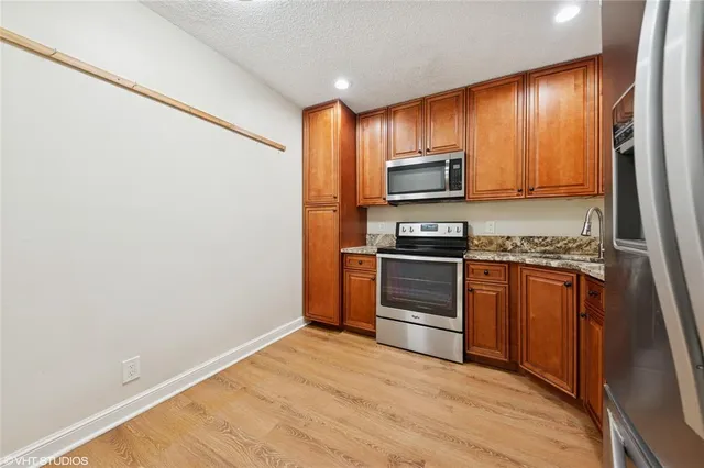 a kitchen with granite countertop stainless steel appliances and wooden cabinets