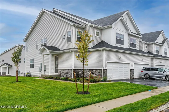 a front view of a house with a yard and trees