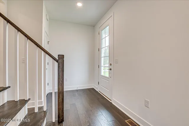 a view of an entryway with wooden floor and door