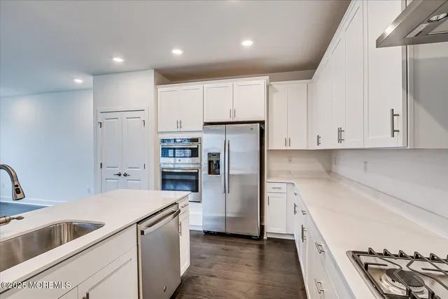 a kitchen with a refrigerator sink and cabinets