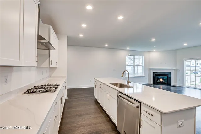 a kitchen with granite countertop a sink stove and cabinets