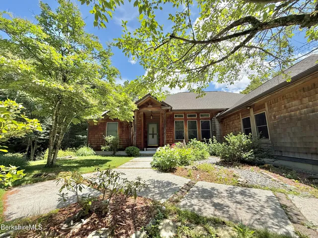 a front view of a house with a yard and potted plants