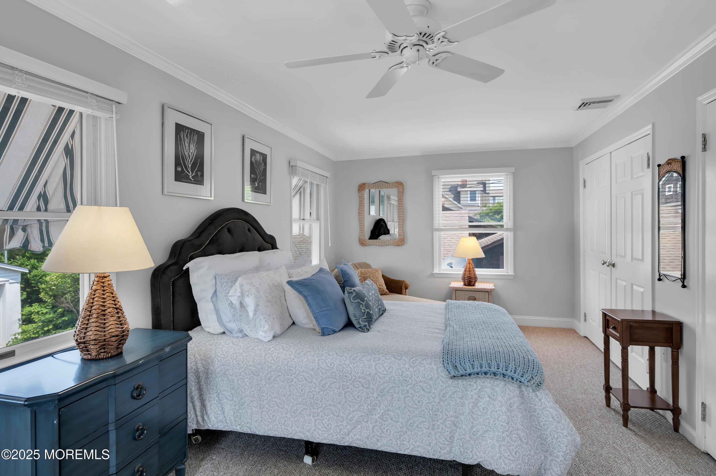 a bedroom with a bed and a lamp on dresser