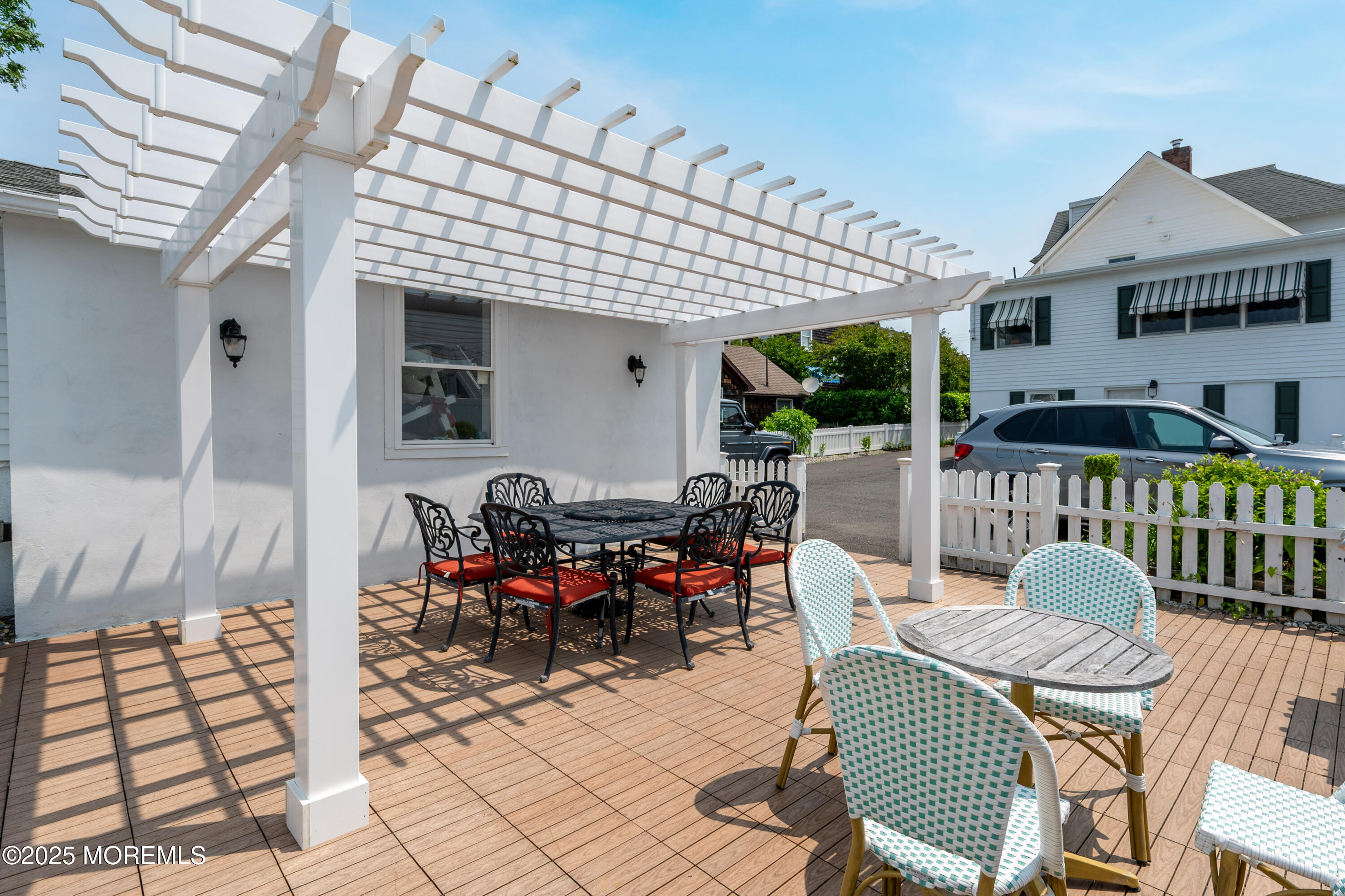 512 Main Avenue, Unit 5 Bay Head, NJ 08742 - Photo 26 of 35 a view of a patio with table and chairs potted plants with wooden floor and fence