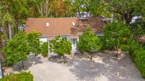 an aerial view of a house with yard and outdoor seating