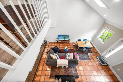 a kitchen with stainless steel appliances granite countertop a dining table chairs and a refrigerator