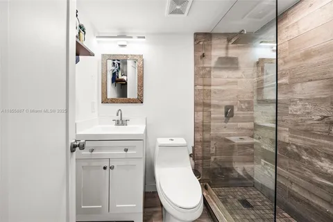 a large white kitchen with stainless steel appliances granite countertop a refrigerator and a stove top oven