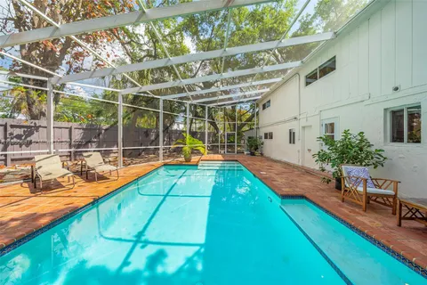 a view of a backyard with a patio and swimming pool