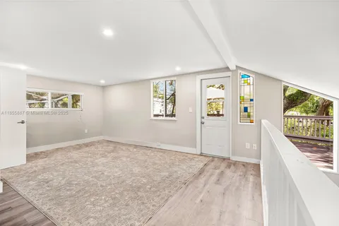 a backyard of a house with table and chairs under an umbrella