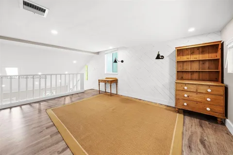 a room with pool table and a wooden floor