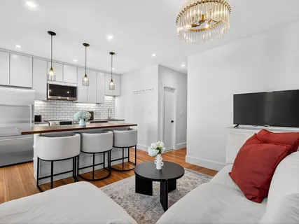 a living room with furniture a rug and kitchen view