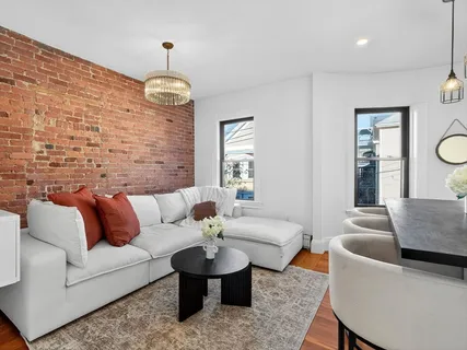 a living room with fireplace furniture and a rug