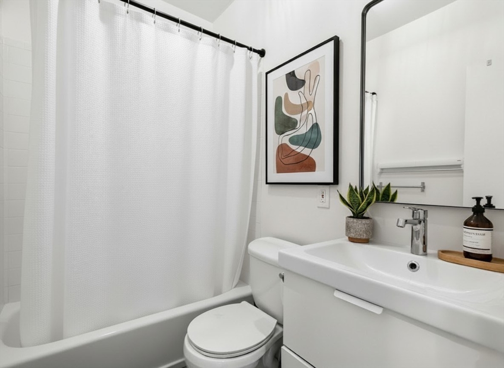 217 Boylston Street, Unit 3 Boston, MA 02130 - Photo 8 of 12 a bathroom with a toilet a sink and a mirror