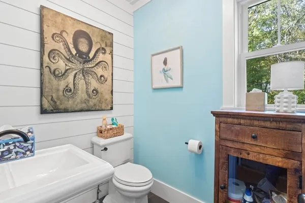 a bathroom with a toilet a sink and a window