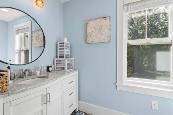 a bathroom with a granite countertop toilet a sink and a mirror