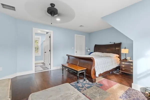 a bedroom with a bed and wooden floor