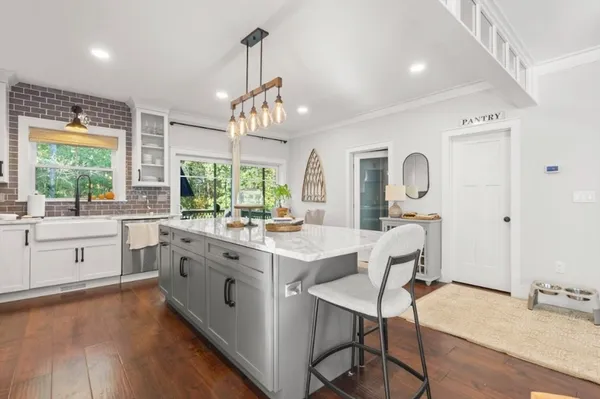 a kitchen with stainless steel appliances granite countertop a sink cabinets and wooden floor