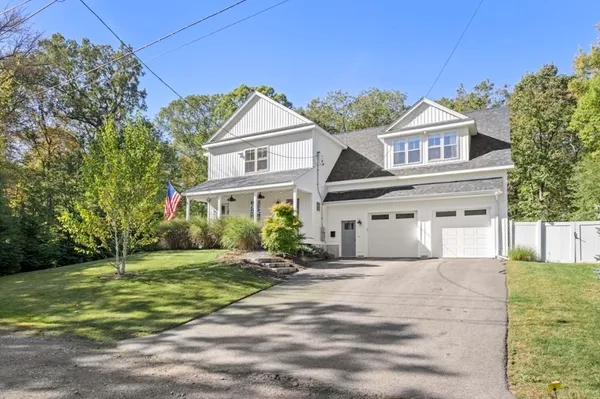 a view of a white house with a big yard and large trees