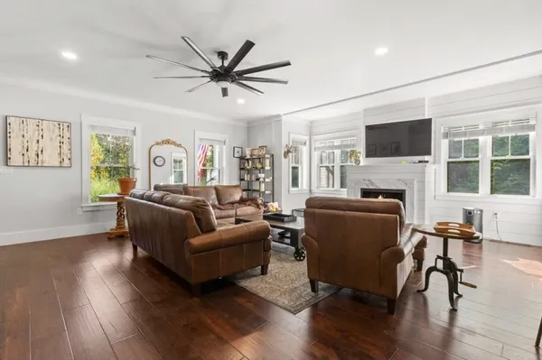 a living room with furniture a fireplace and a flat screen tv