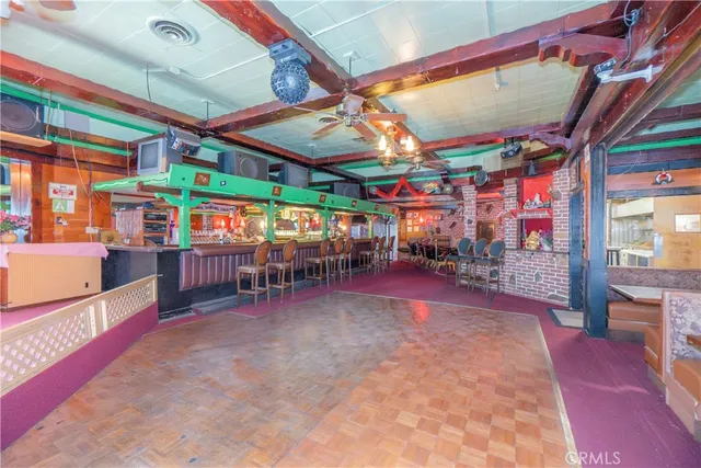 a view of a room with lots of furniture and a kitchen view