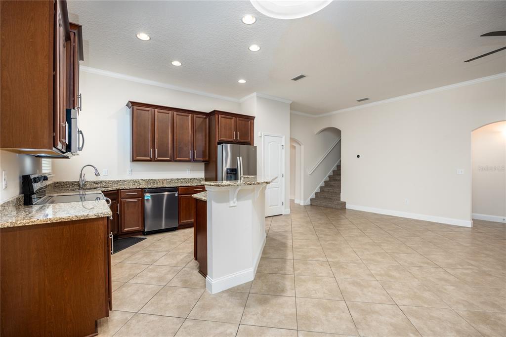8216 Northwest 54th Street Gainesville, FL 32653 - Photo 27 of 57 a kitchen with kitchen island granite countertop a stove a sink a counter top space and cabinets