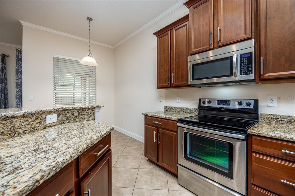 8216 Northwest 54th Street Gainesville, FL 32653 - Photo 30 of 57 a kitchen with stainless steel appliances granite countertop wooden cabinets stove a sink and dishwasher