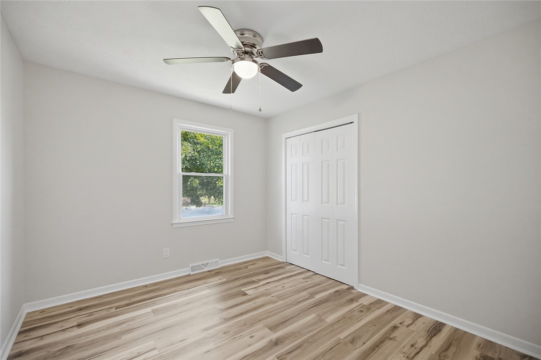 902 Cherokee Road Pelzer, SC 29669 - Photo 4 of 38 A well-lit bedroom features durable laminate flooring and a contemporary ceiling fan for comfort.