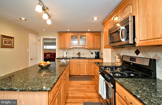 a kitchen with granite countertop a sink a counter top space appliances and cabinets