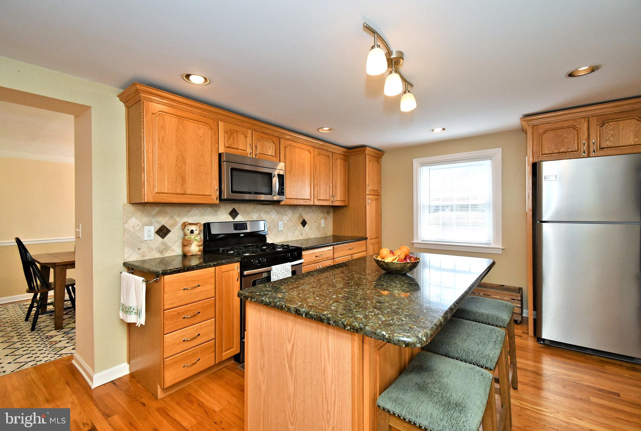 442 Oreland Mill Road Oreland, PA 19075 - Photo 15 of 68 a kitchen with granite countertop a stove a sink dishwasher a refrigerator with wooden cabinets and floor