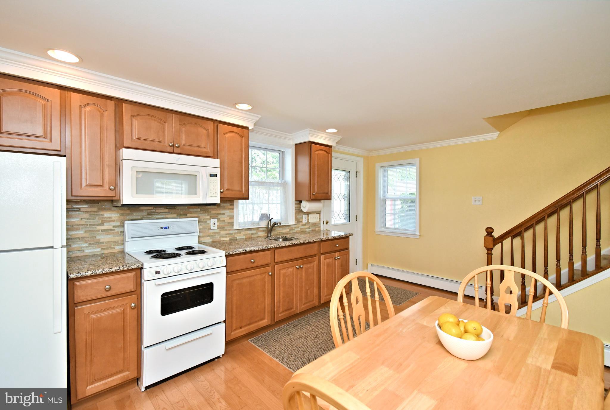 442 Oreland Mill Road Oreland, PA 19075 - Photo 45 of 68 a kitchen with stainless steel appliances granite countertop a stove a sink a refrigerator and white cabinets with wooden floor