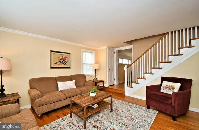 a living room with furniture wooden floor and a large window