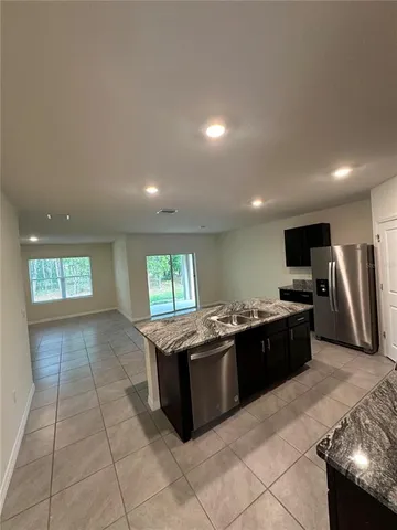a large kitchen with stainless steel appliances granite countertop a sink and a stove