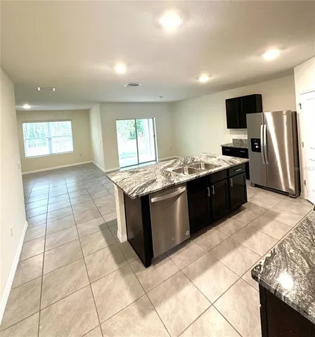 a kitchen with stainless steel appliances granite countertop a stove a sink and a refrigerator