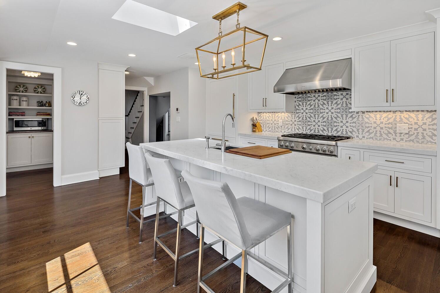 9 Beach Drive Darien, CT 06820 - Photo 17 of 39 a kitchen with stainless steel appliances a white table chairs and a refrigerator