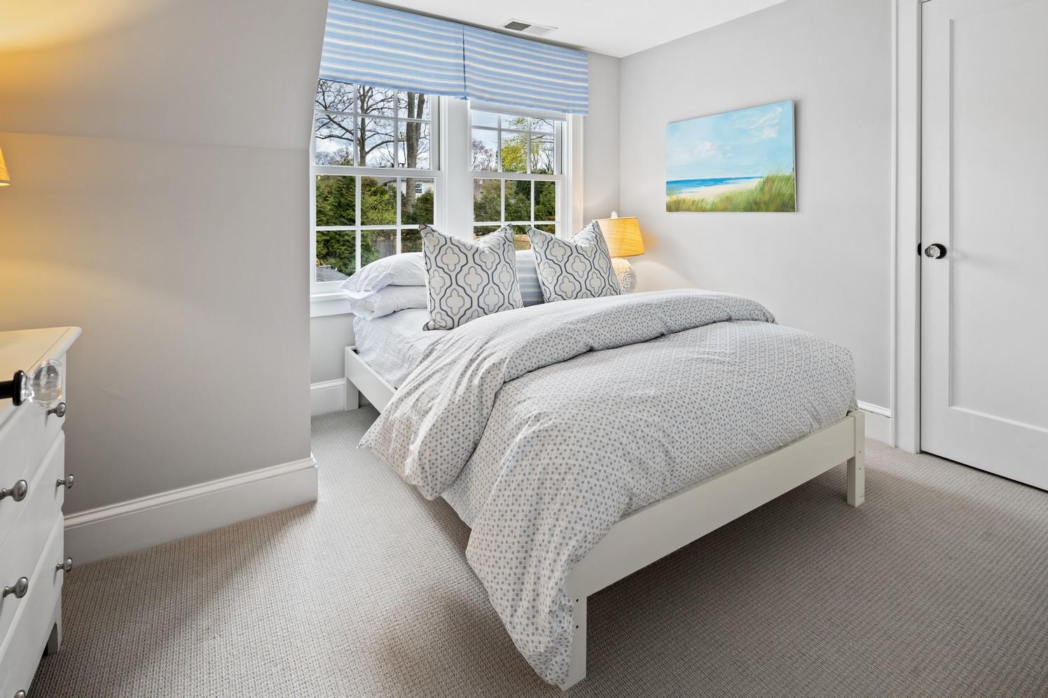 9 Beach Drive Darien, CT 06820 - Photo 32 of 39 a bedroom with a bed and a large window