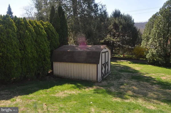 a front view of a house with a yard and trees