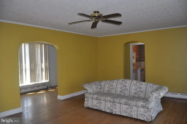 a living room with a couch and a ceiling fan