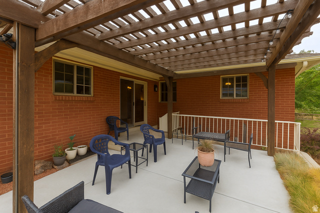 16535 South Redwood Road Riverton, UT 84065 - Photo 45 of 59 Expansive outdoor patio featuring a wood pergola, concrete surface, brick exterior, and white railing