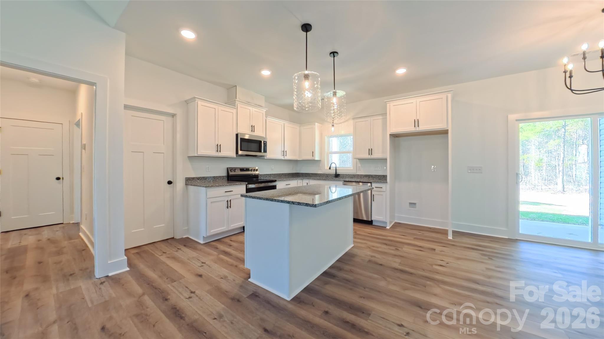 4018 Deerstone Lane, Unit 24 Clover, SC 29710 - Photo 14 of 48 a kitchen with stainless steel appliances granite countertop a refrigerator a sink dishwasher a stove and white countertops with wooden floor