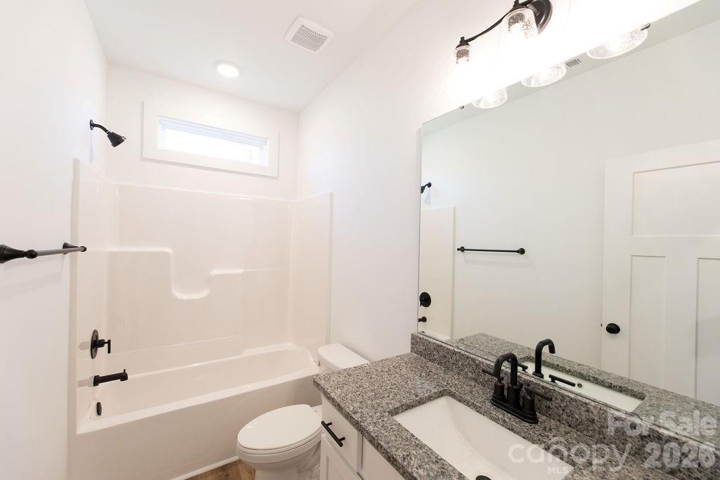 4018 Deerstone Lane, Unit 24 Clover, SC 29710 - Photo 25 of 48 a bathroom with a granite countertop sink toilet a mirror and shower