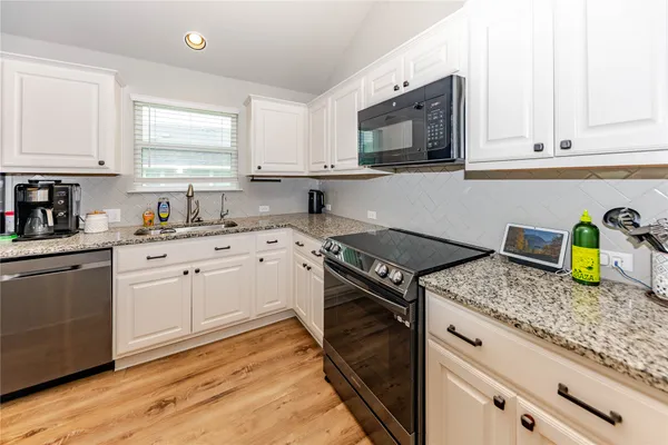 a kitchen with sink a stove and cabinets