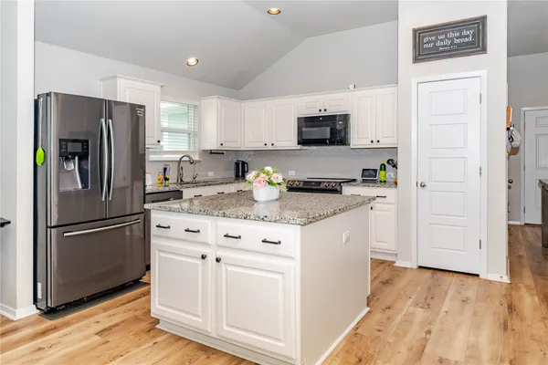 a kitchen with white cabinets and stainless steel appliances