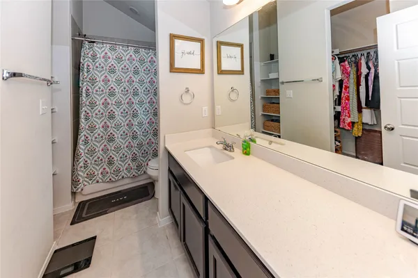 a bathroom with a toilet and a shower curtain